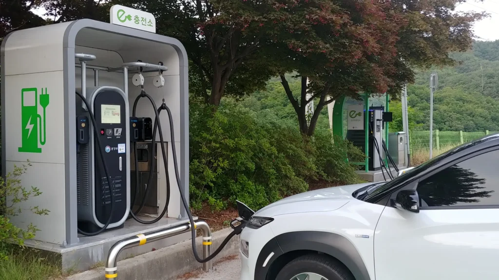 공공 급속 충전소에서 충전 중인 EV와 걱정하는 운전자